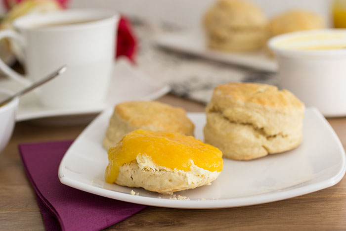 Orange scones, cut and filled with clotted cream and orange jam