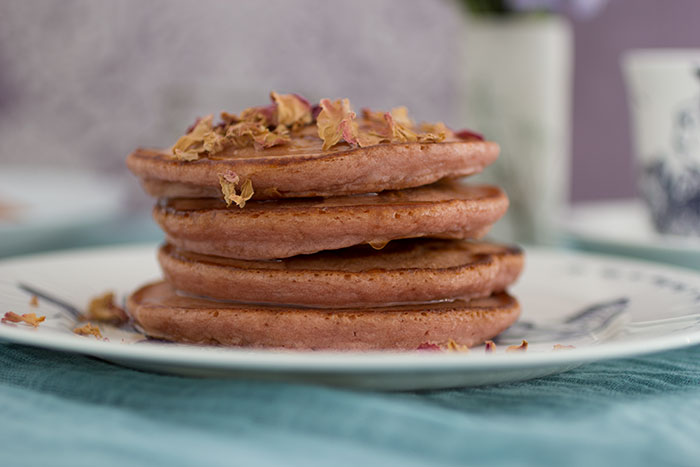 Rose pancakes stack with syrup and rose petals