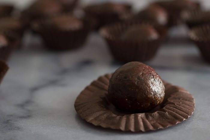 Vegan Chocolate Truffles. Close up of one truffle with many seen in the background